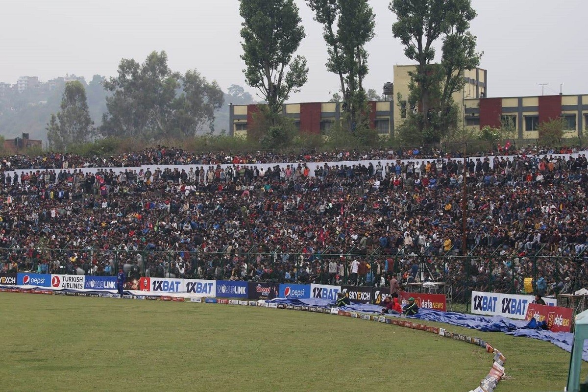  अझै रोकिएन वर्षा, छाता ओढेर दर्शक खेल हेर्न कुर्दै (फोटो फिचर)